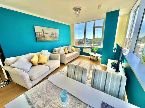 a living room with two couches and a blue wall at Gorgeous Sea View Two Bed Apartment - Close to Beach with Free Parking in Bournemouth