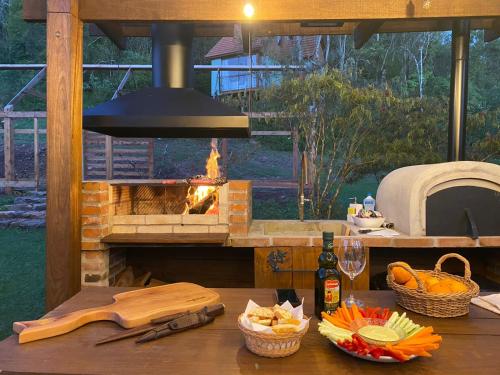 a kitchen with a brick oven and a table with food at Cabana Mirim Estalagem Rural in Gramado