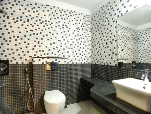 ein Badezimmer mit einem WC, einem Waschbecken und einer Badewanne in der Unterkunft Hotel Badrika Inn in Rewa