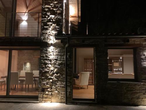 een stenen gebouw met een tafel en stoelen 's nachts bij Sous Un Ciel Différent Struttura con sauna privata in Cortemilia
