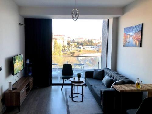 uma sala de estar com um sofá azul e uma grande janela em Luxury flat with Sea & City view - Gym & Parking ( 93 ) - 9255745 em Beylikdüzü