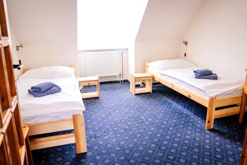 a room with two beds in a room at Hotel Gong in Štramberk