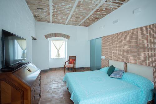 1 dormitorio con 1 cama y TV en Arcadia Agriturismo, en San Nicola Manfredi