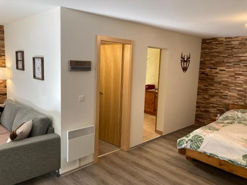 a bedroom with a bed and a couch and a brick wall at Ferienwohnung Morgengruss in Sankt Niklaus