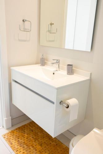 La salle de bains est pourvue d'un lavabo blanc et d'un miroir. dans l'établissement Modernday Homes, à Johannesbourg