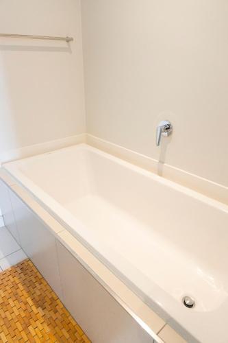 La salle de bains est pourvue d'une baignoire blanche et d'un lavabo. dans l'établissement Modernday Homes, à Johannesbourg