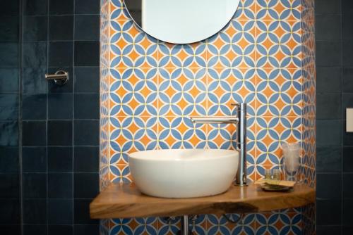 baño con lavabo y pared de azulejos azules en Arcadia Agriturismo, en San Nicola Manfredi