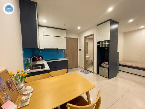 a kitchen with a wooden table and a dining room at It Dust Homestay 1 - The Ocean Apartment in Hanoi