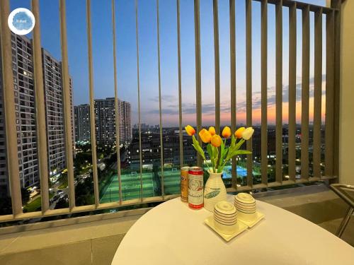 een tafel met een vaas met bloemen op een balkon bij It Dust Homestay 1 - The Ocean Apartment in Hanoi