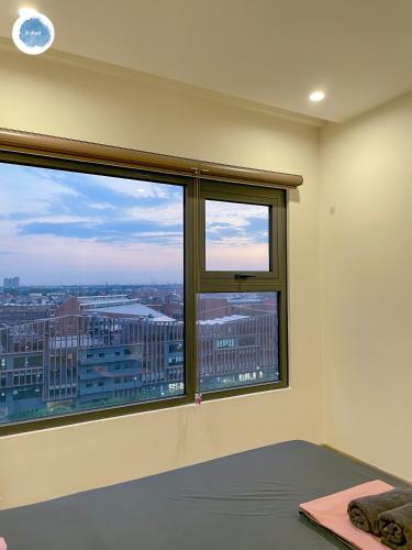 a bedroom with a large window with a view at It Dust Homestay 1 - The Ocean Apartment in Hanoi