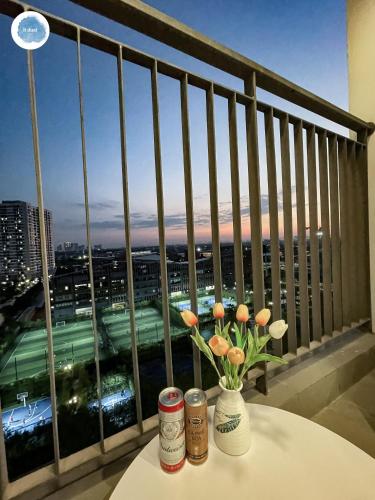 a table with flowers on a balcony with a view at It Dust Homestay 1 - The Ocean Apartment in Hanoi