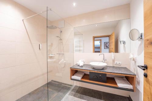 La salle de bains est pourvue d'un lavabo et d'une douche. dans l'établissement Appartement "Sonnenreich" im Carpe Solem, à Mariapfarr