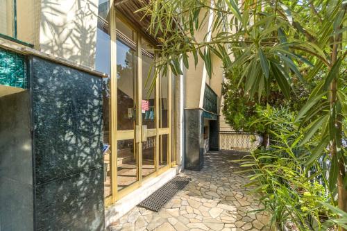 a building with glass doors and a courtyard with plants at Asti Comfy Apartment - Private Parking! in Asti