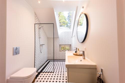La salle de bains est pourvue de toilettes blanches et d'un lavabo. dans l'établissement Dirhami Pool Villa, à Dirhami