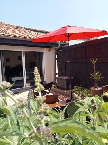a patio with an umbrella and a table and chairs at Gite de PHAM in Belberaud