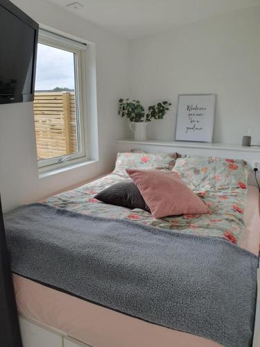 a bed with a pillow and a window in a room at K39 in Laholm