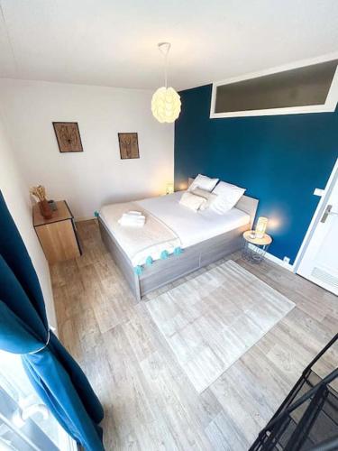 une chambre avec un lit et un mur bleu dans l'établissement L'Étoile • Spacieux • Stationnement facile, à Châteauroux