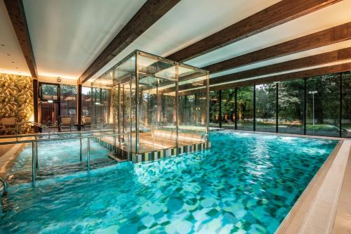 an indoor swimming pool with a glass wall at Wasa Historical 1938 Boutique Hotel in Pärnu