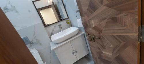 a bathroom with a sink and a toilet and a mirror at The Candy Nest in Rānchī