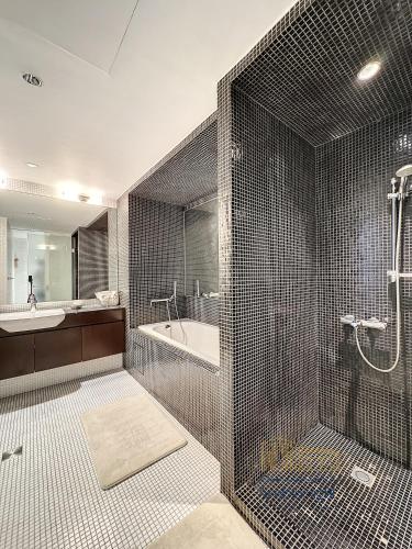 a bathroom with a shower and a tub and a sink at La Casa By Arabian Nights - City View - Bespoke Design in Dubai
