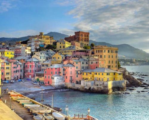 een stad met kleurrijke huizen en boten in het water bij Lido Blu in Genua