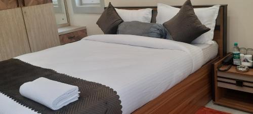 a bedroom with a large bed with white sheets and pillows at The Candy Nest in Rānchī