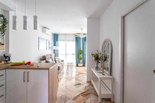 kuchnia i salon z białymi szafkami i stołem w obiekcie OleHolidays 315 Romana Playa primera linea playa w Marbelli