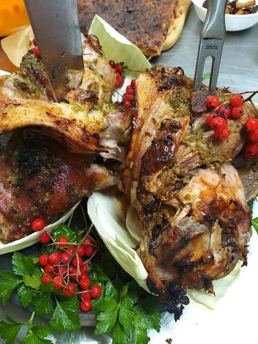 a plate of food with meat and vegetables with a knife at Zirgu sēta "Klajumi" - Horse ranch "Klajumi" in Kaplava