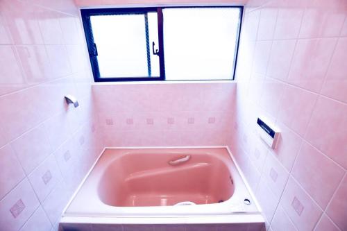 a pink bath tub in a bathroom with a window at NEW OPEN 4BR, 110㎡ Walk to Asakusa in Tokyo