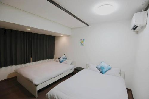 a bedroom with two beds and a flat screen tv at NEW OPEN 4BR, 110㎡ Walk to Asakusa in Tokyo