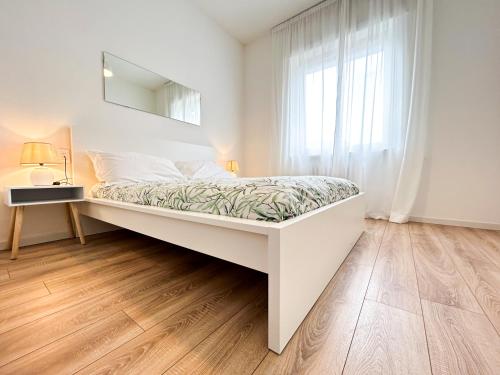 een witte slaapkamer met een bed en een raam bij Lodge 99 in Pescara