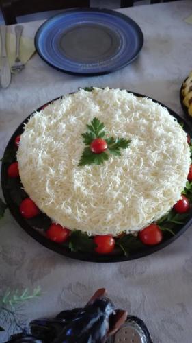 a white cake on a plate on a table at Zirgu sēta "Klajumi" - Horse ranch "Klajumi" in Kaplava
