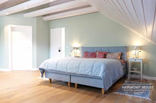 a bedroom with a blue bed with pink pillows at Harmony House in Handewitt