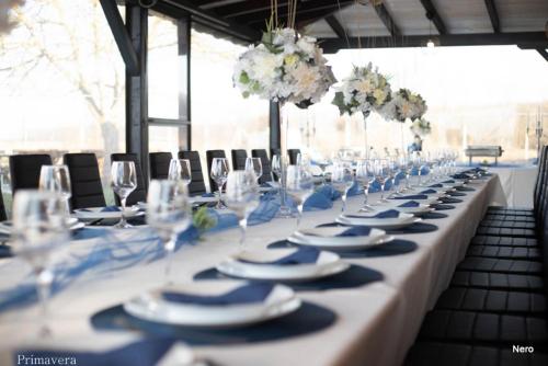 a long table with white plates and wine glasses at Kuća za odmor Primavera in Vinkovci