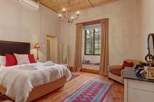 een slaapkamer met een bed, een bank en een raam bij Buccara Wildlife Reserve in Graaff-Reinet