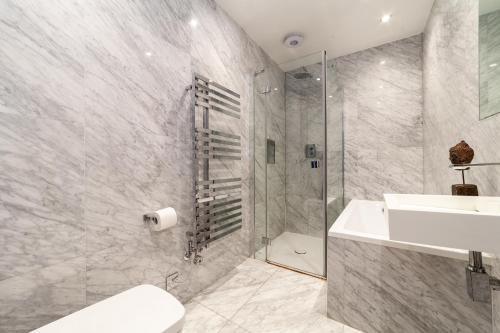 a bathroom with a sink and a toilet and a shower at The South Hampstead Collection in London