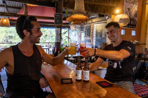 two men sitting at a bar drinking beer at Kampot Cabana in Kampot