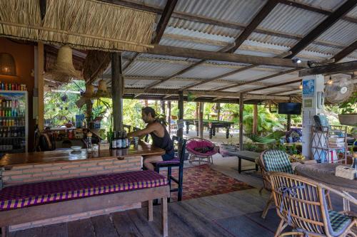 a woman sitting at a bar in a restaurant at Kampot Cabana in Kampot