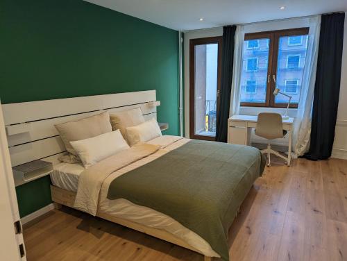 Un dormitorio con una cama grande y una pared verde en Goldstadt Apartments en Pforzheim