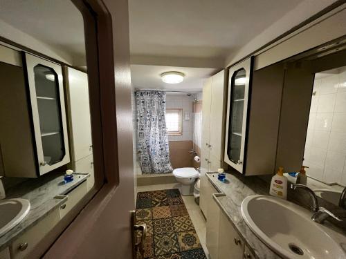 a bathroom with two sinks and a toilet and a tub at Beit Zaman hostel in Beit Sahour