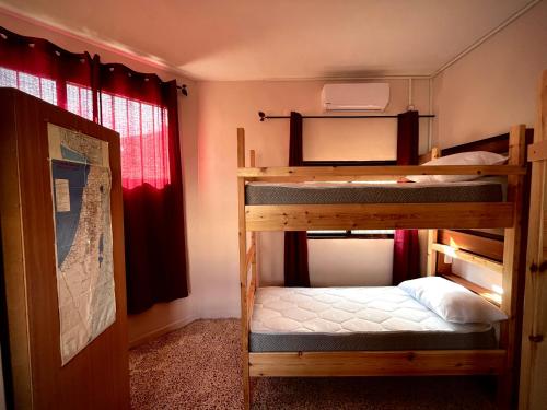 two bunk beds in a room with a window at Beit Zaman hostel in Beit Sahour