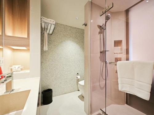 a bathroom with a shower with a toilet and a sink at Citrus Sukhumvit 13 Nana Bangkok by Compass Hospitality in Bangkok