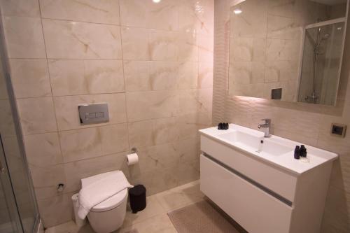 y baño con lavabo, aseo y espejo. en Charming 3bdr Apartment For A Memorable Stay, en Basaksehir