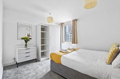 a white bedroom with a bed and a mirror at Cubo Canary Wharf in London