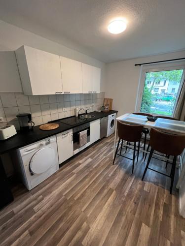 a kitchen with a table and chairs in a room at Apartments in Schöner Lage in Mönchengladbach in Mönchengladbach