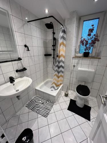 a white bathroom with a sink and a toilet at Apartments in Schöner Lage in Mönchengladbach in Mönchengladbach