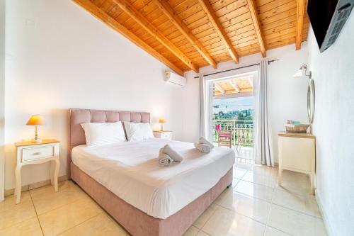 a bedroom with a bed and a large window at Arianna Deluxe Studio 21 in Paleokastritsa