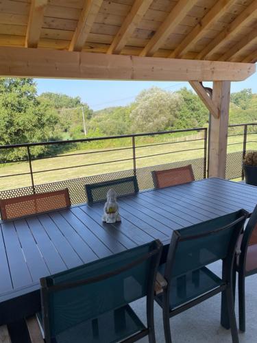 une table bleue et des chaises sur une terrasse dans l'établissement Gîte en Soi, à Montracol
