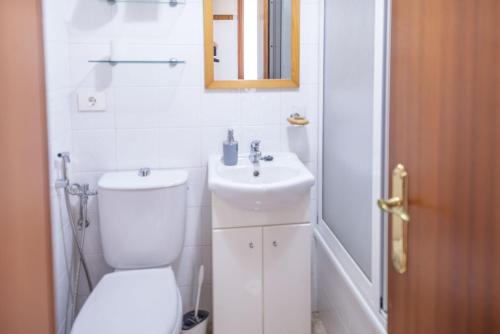 a white bathroom with a toilet and a sink at Lightbooking El Burrero in Ingenio
