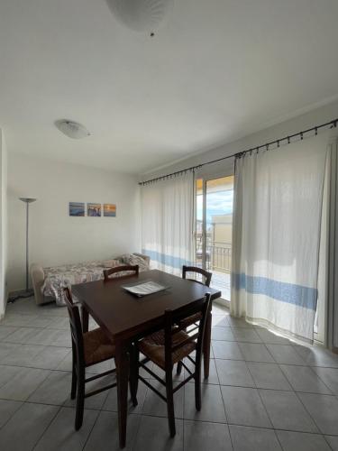 een eetkamer met een tafel en stoelen en een raam bij Casa Victoria in Golfo Aranci